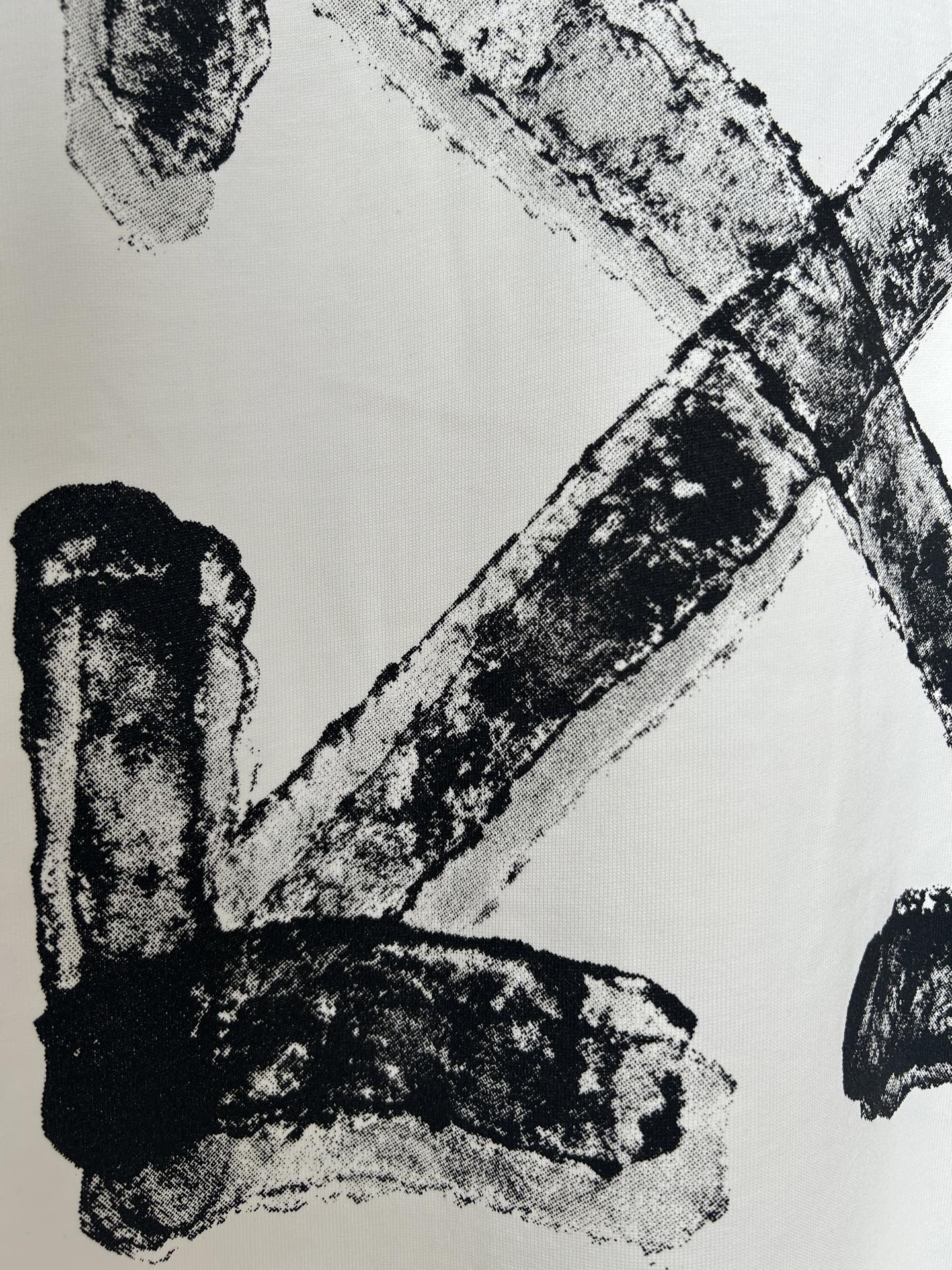 Off-white T-shirt close-up of black logo letter strokes