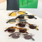 Assorted round sunglasses with gold, tortoise, and black frames; dark lenses laid out.