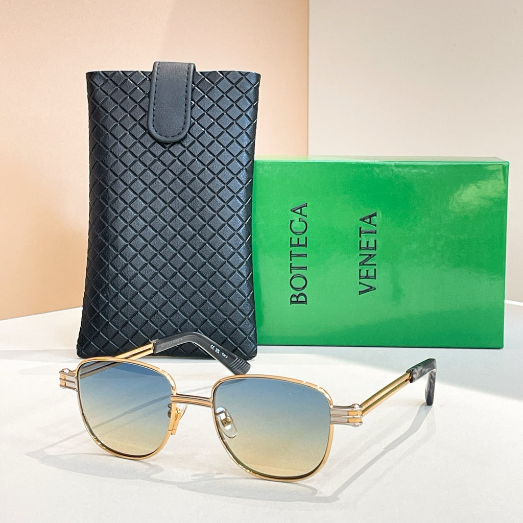 Bottega Veneta sunglasses with amber gradient lenses, gold-tone round frame and arms.