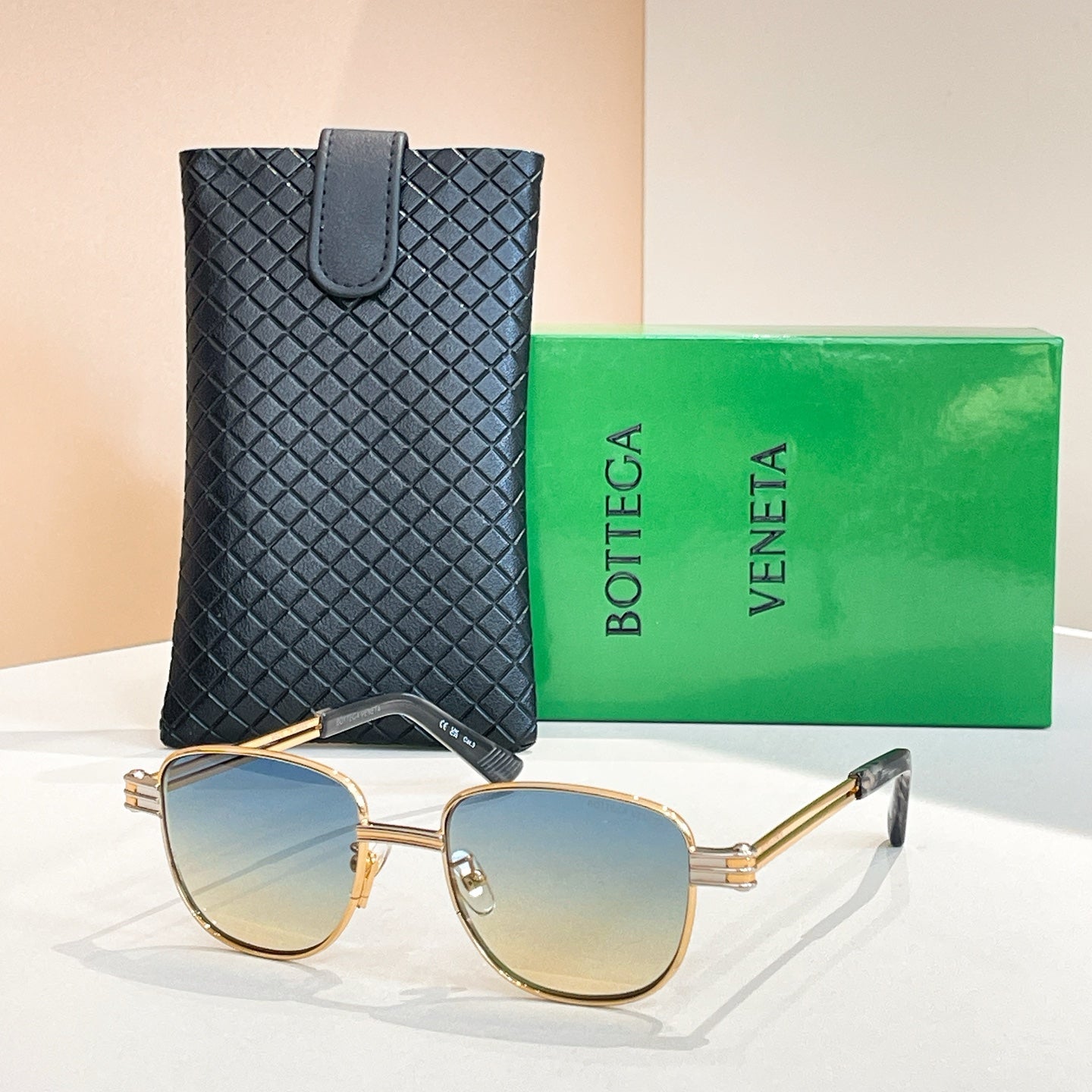 Bottega Veneta sunglasses with amber gradient lenses, gold-tone round frame and arms.