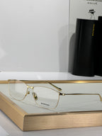 Balenciaga glasses with gold-toned frame and clear lenses, angled view