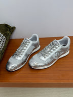 Gray Chanel logo sneakers, two shoes side by side with white laces and embossed details