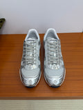 Gray low-top sneakers with white laces and Chanel logo print on the toe and sides