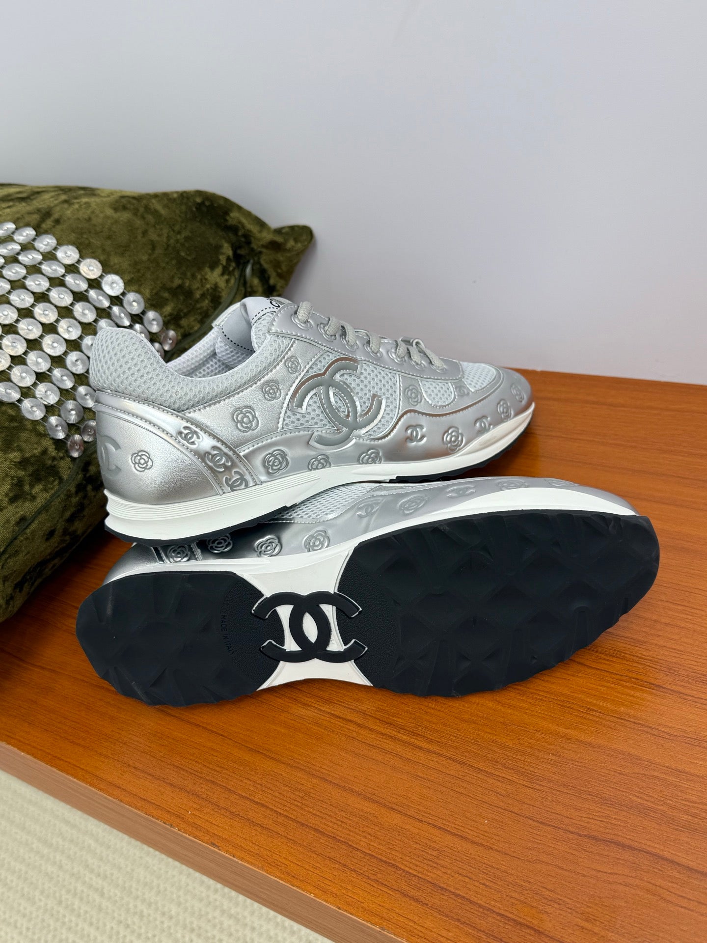 Gray Chanel logo sneakers with visible outsole, tread and signature CC on the heel