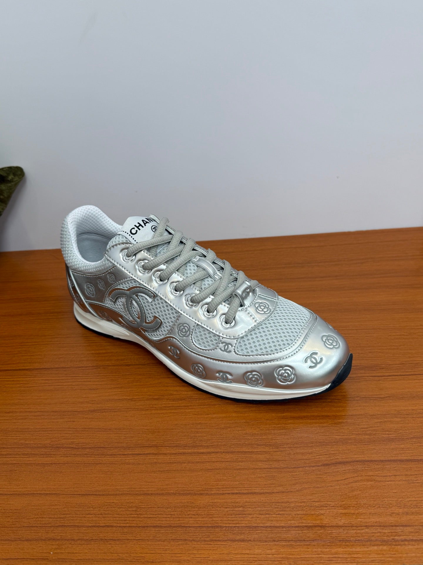 Gray Chanel logo sneakers, side view with textured laces and metallic-look trim