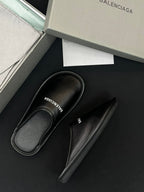Black leather slides with BALENCIAGA logo on insole, one pair view