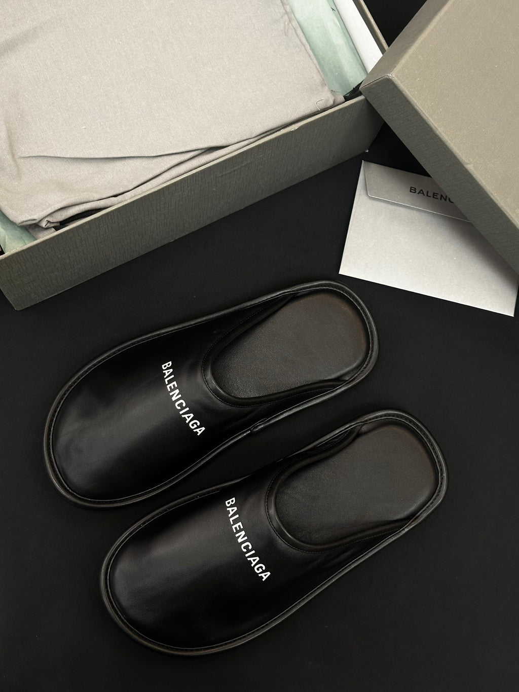Black leather slides with stitched edges, BALENCIAGA logo on insole