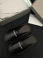 Black leather slides with stitched edges, BALENCIAGA logo on insole