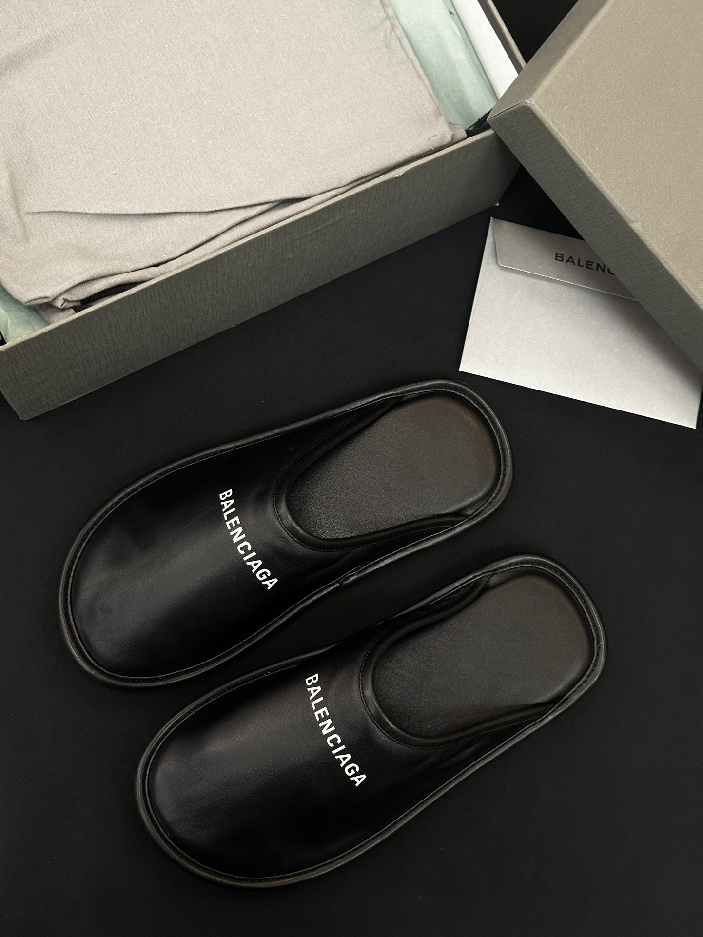 Black leather slides with stitched edges, BALENCIAGA logo on insole