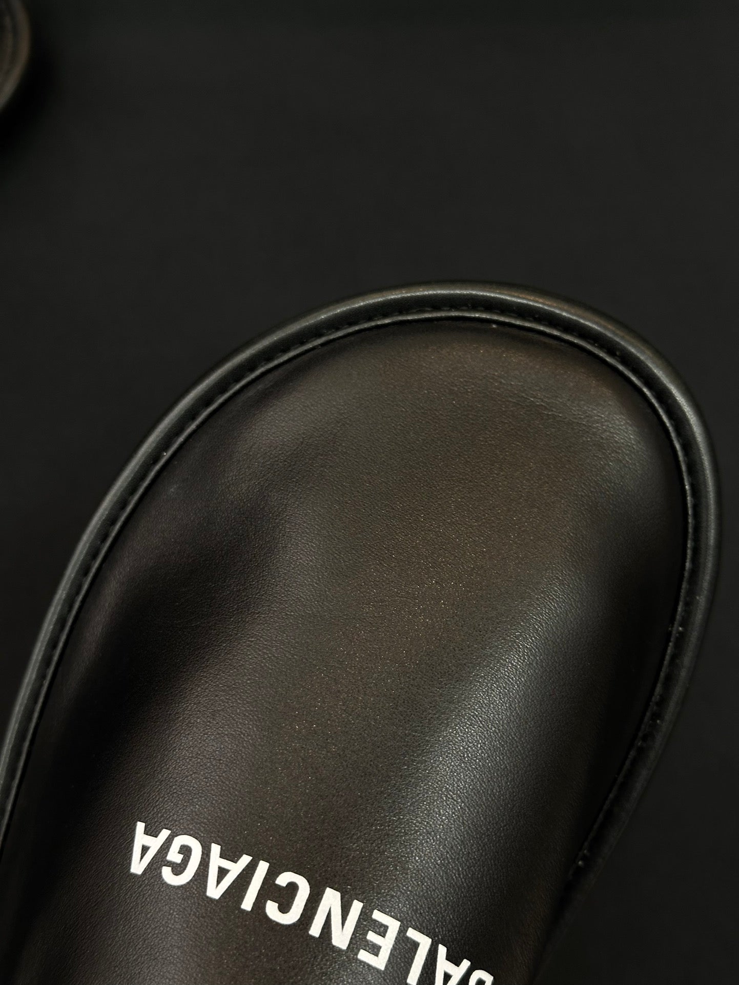 Black leather slide upper close-up with BALENCIAGA insole lettering