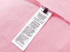 Pink T-shirt care label with size and fabric information inside neck