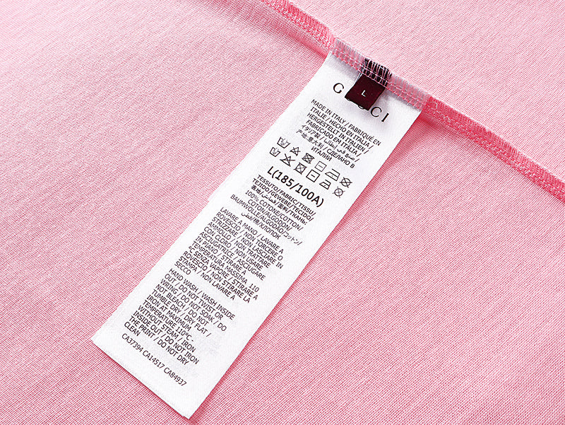 Pink T-shirt care label with size and fabric information inside neck