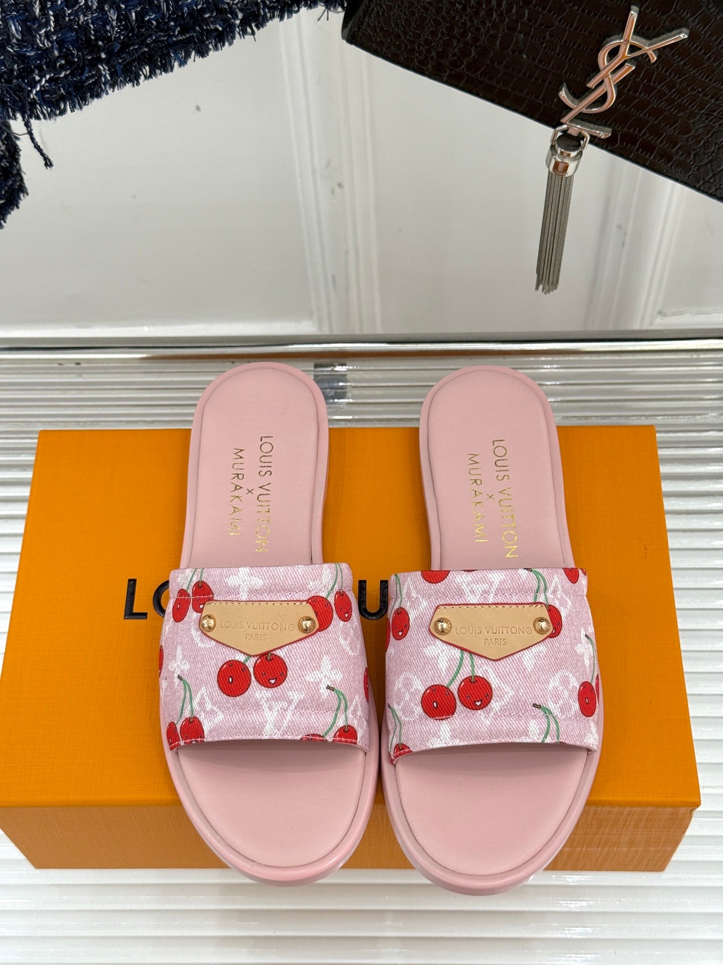 Pink cherry-print slide sandals with gold-tone buckles and cushioned footbeds