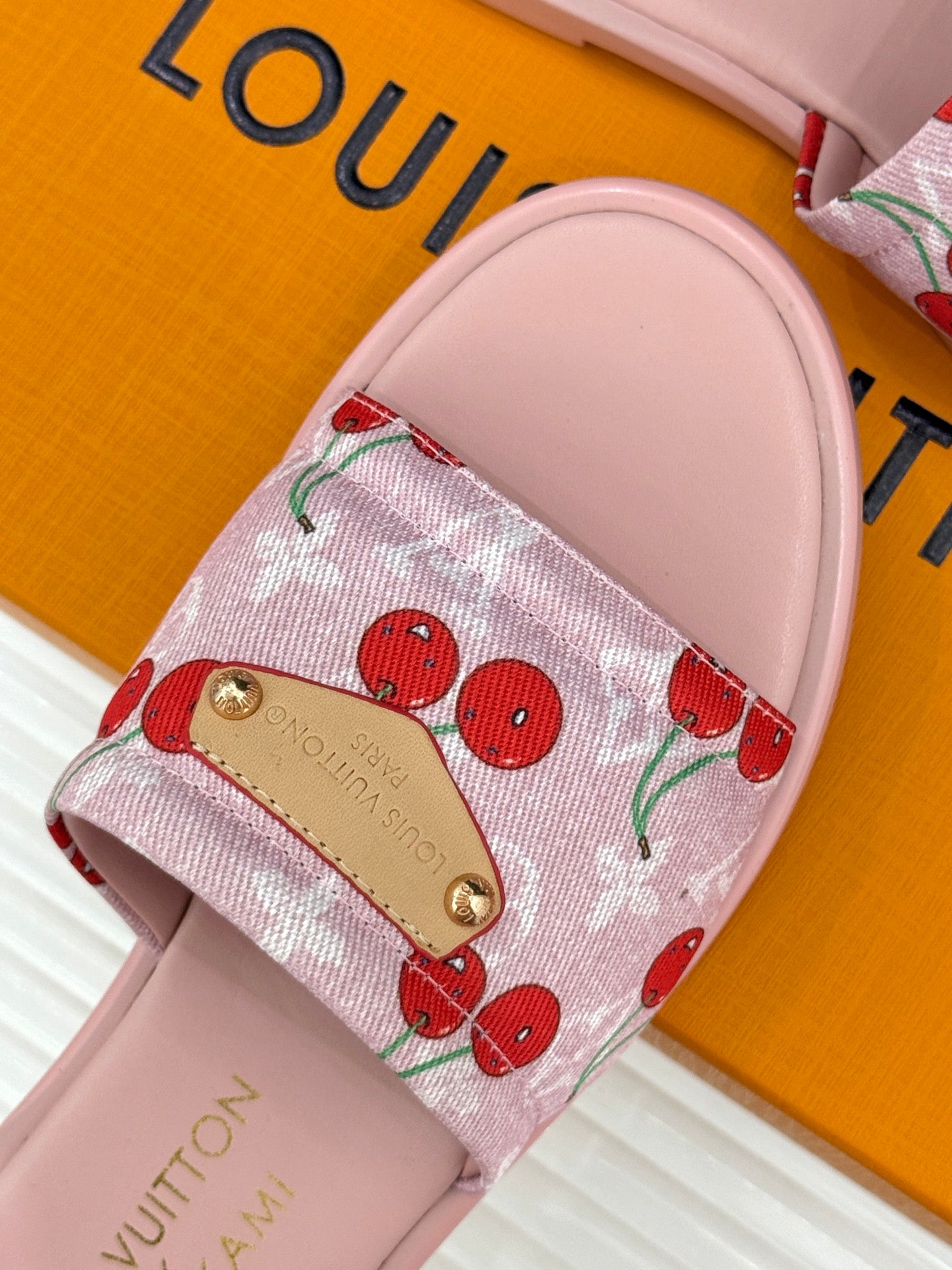 Cherry-print slide sandals with gold-tone buckle on pink cushioned footbed