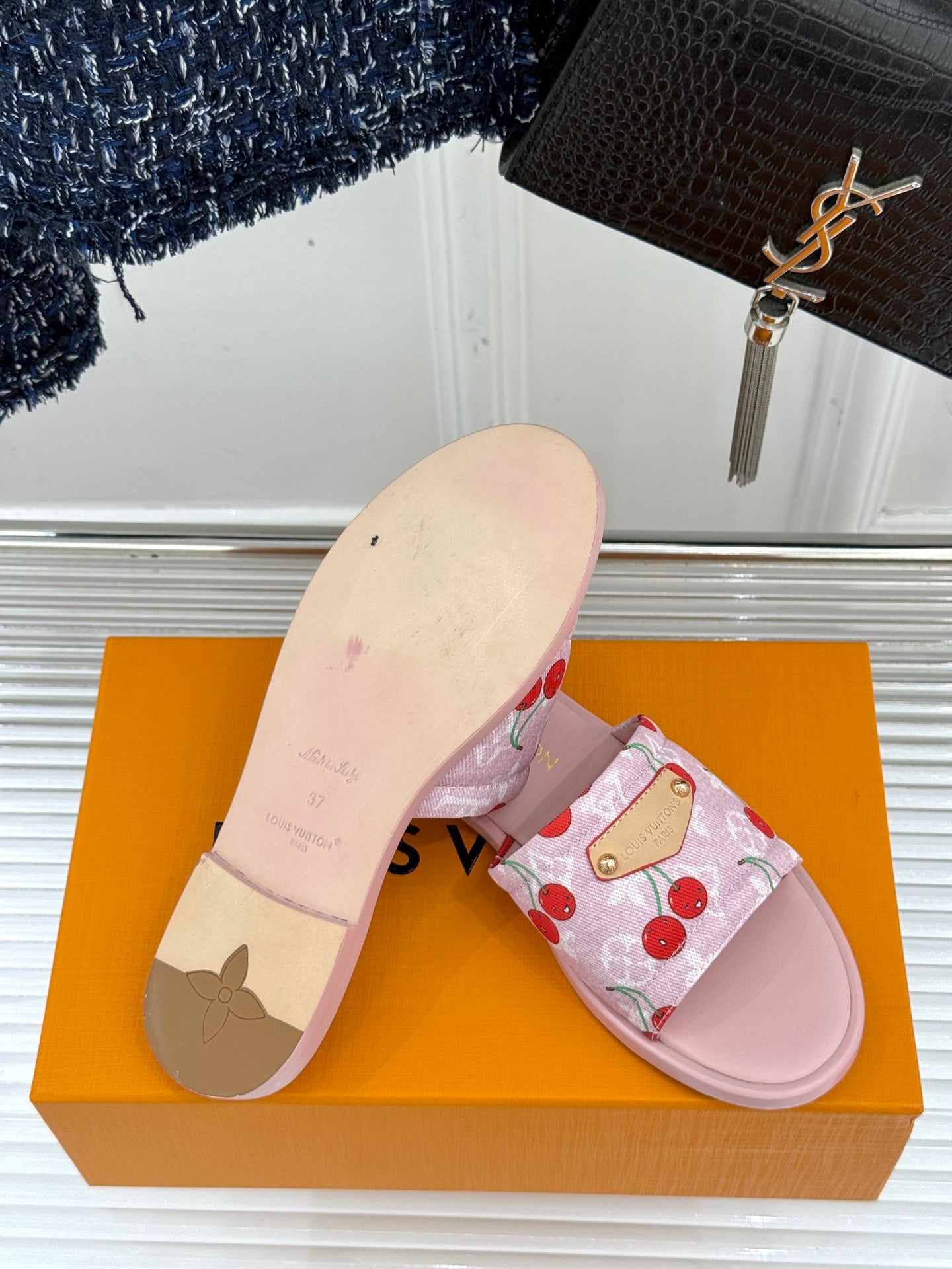 Pink cherry-print slide sandal with textured light outsole and gold-tone buckle