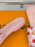 Close-up of light pink slide sandal footbed and cherry-print fabric strap