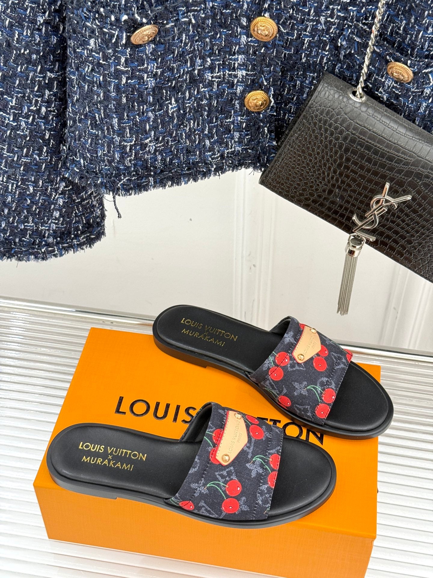 Louis Vuitton women's slide sandals with cherry print strap and gold detail.