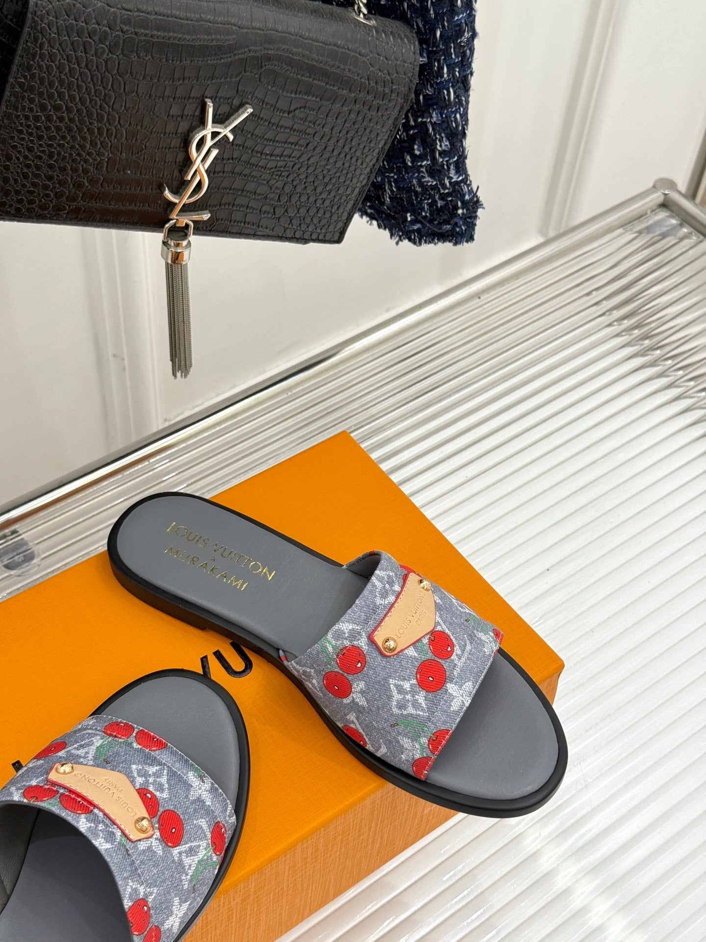 Women’s slide sandals with gray sole and blue denim cherry-print strap close view
