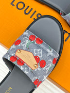 Women’s slide sandals close-up: blue cherry-print denim strap with tan logo patch