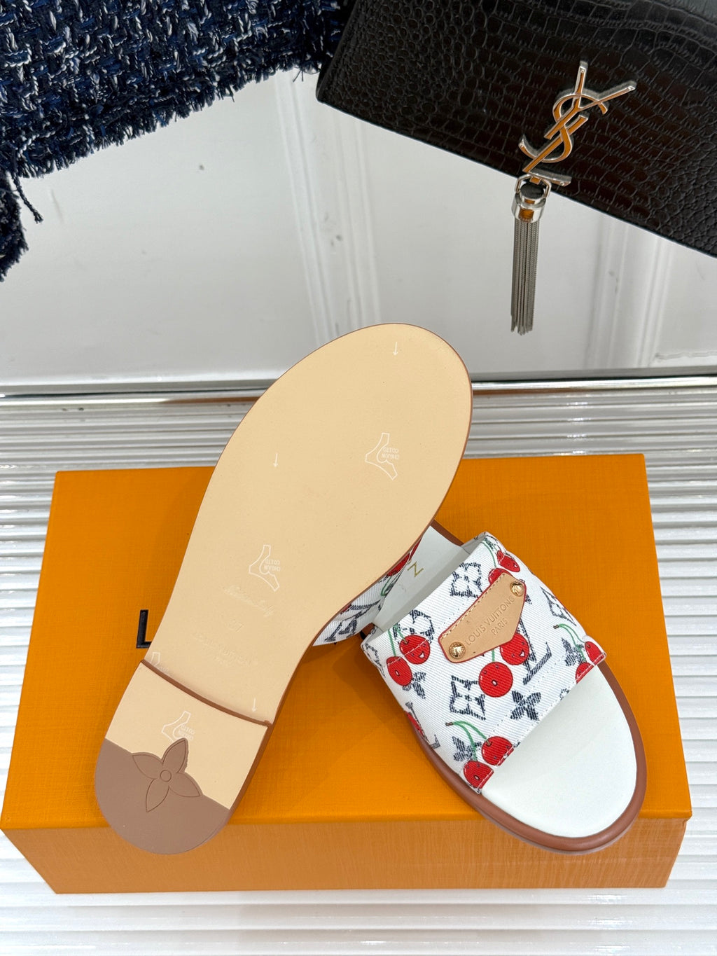 Ladies slide sandal with white cherry-pattern strap and light beige outsole