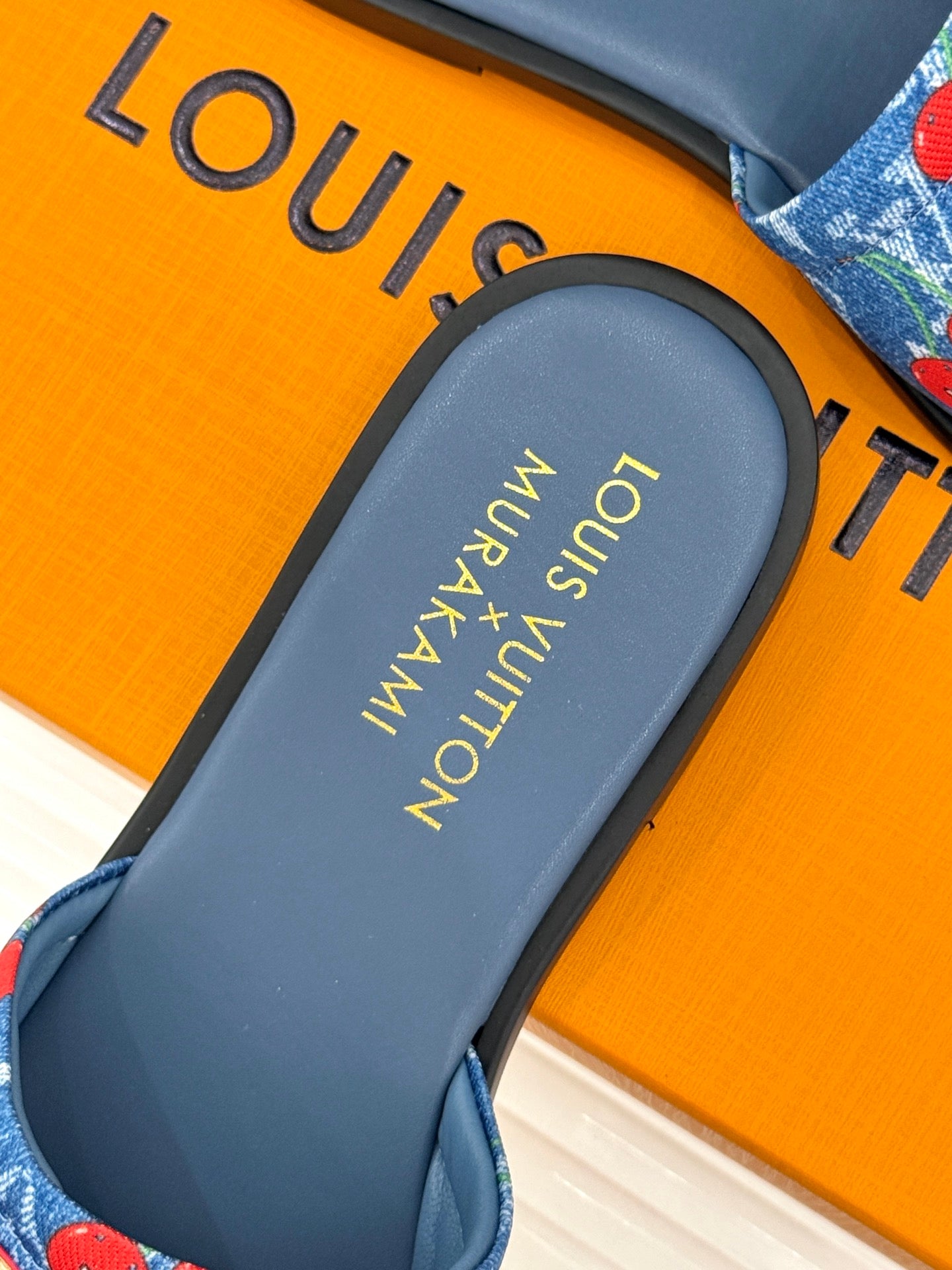 Louis Vuitton blue slide sandal footbed with “Louis Vuitton” logo text