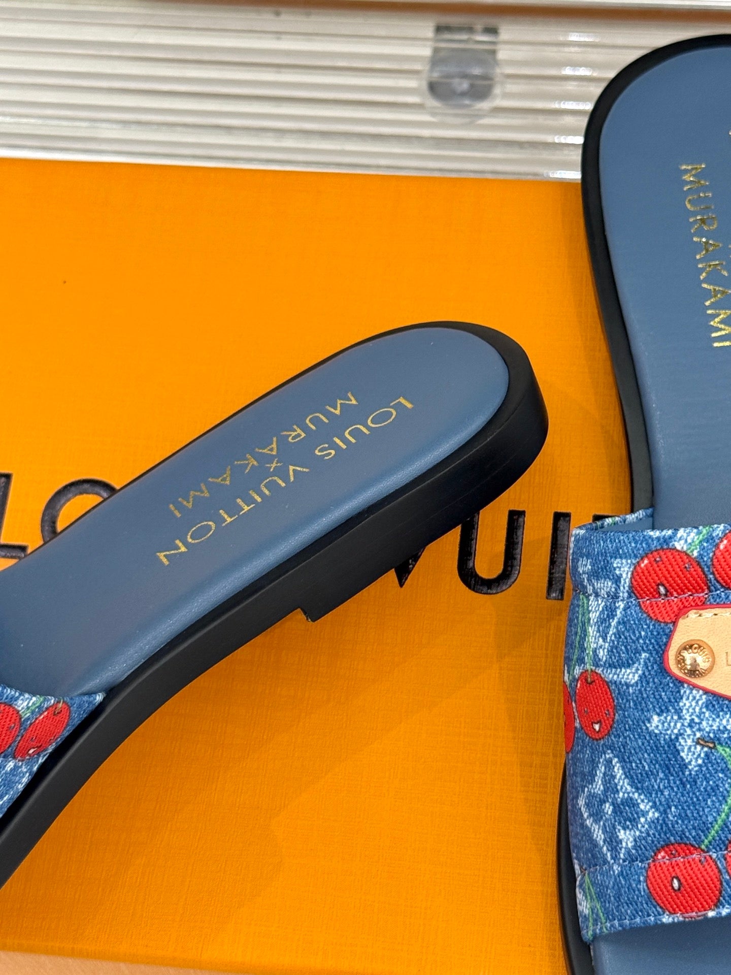 Louis Vuitton blue slide sandal footbed with printed brand text, close-up