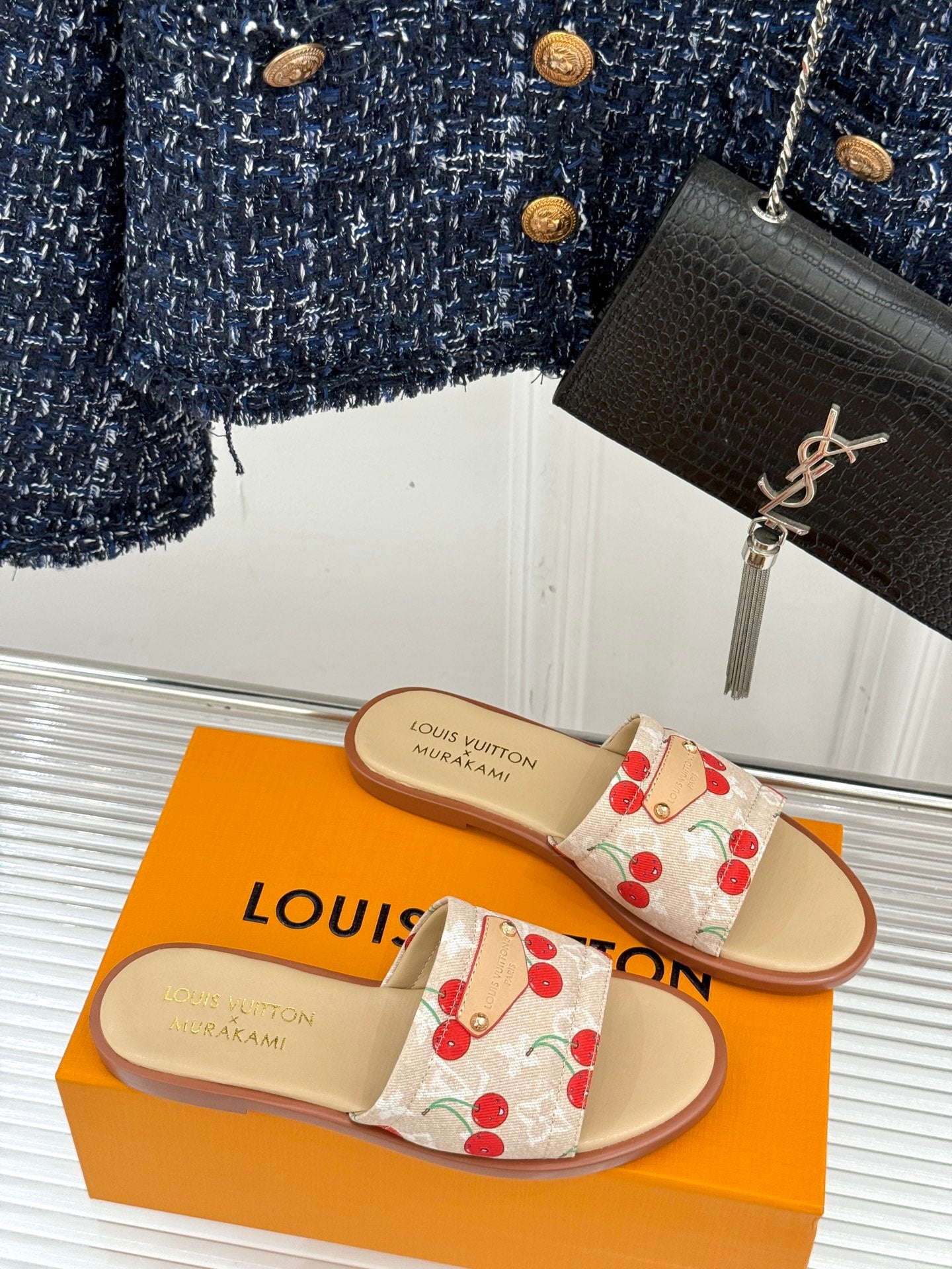 Louis Vuitton cherry-print slide sandals on orange box, pair view