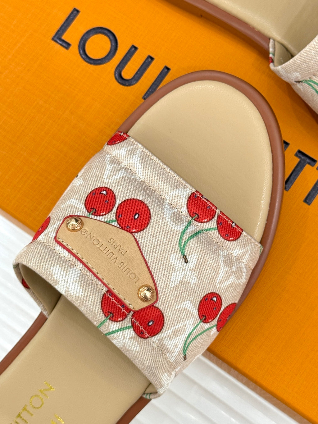 Louis Vuitton cherry-print slide sandal strap with gold button detail