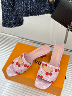 Pink cherry-print Louis Vuitton slide sandals with low block heel on orange box
