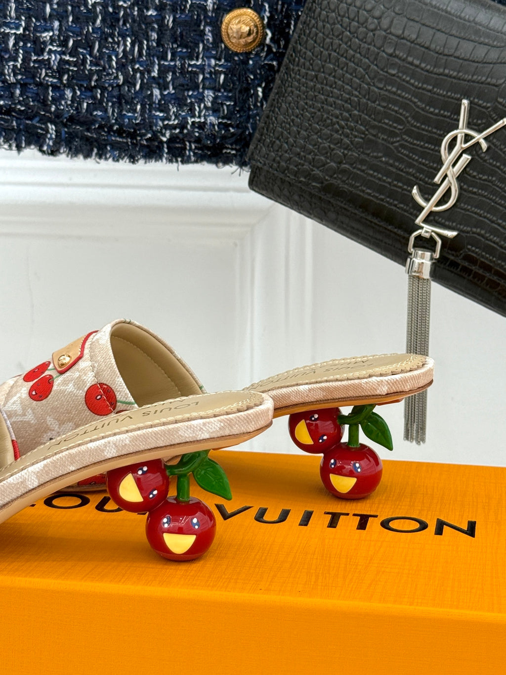 Beige cherry-print flat mules with open toe and gold-tone logo strap.