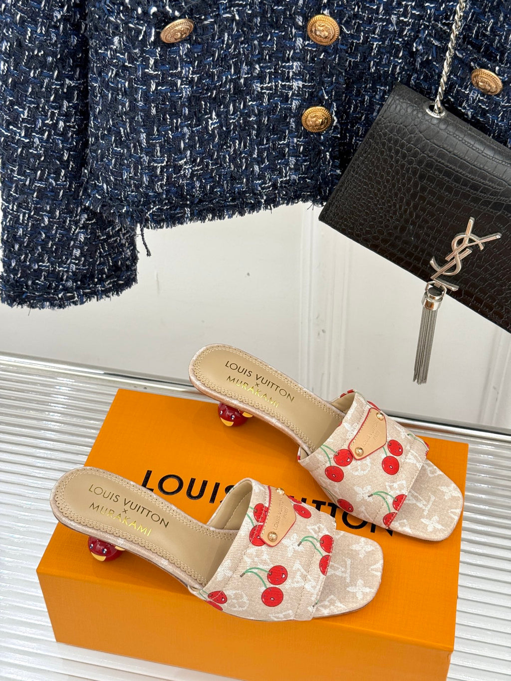 Cherry-print flat mule sandals with beige straps and gold Louis Vuitton logo.