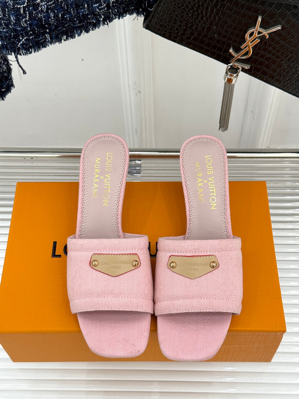 Pink slide sandals pair with gold buckle plates and stitched strap edges