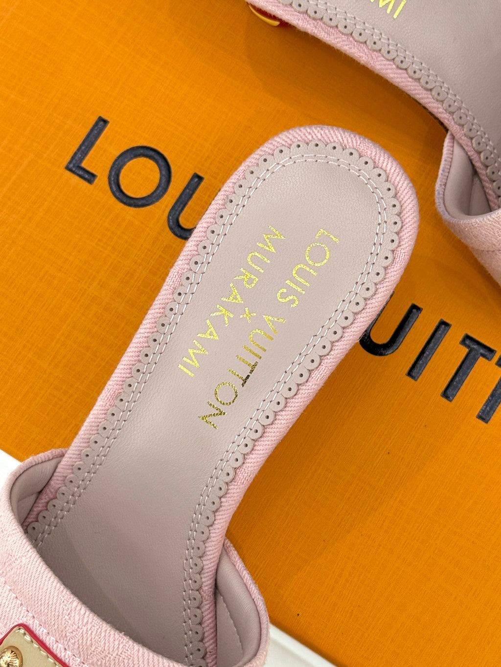 Pink slide sandal insole close-up with gold Louis Vuitton logo text