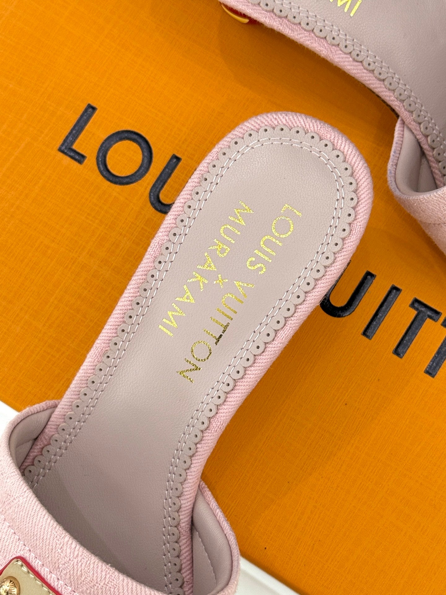 Pink slide sandal insole close-up with gold Louis Vuitton logo text