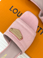 Pink slide sandal strap close-up with gold buckle plate and stitching
