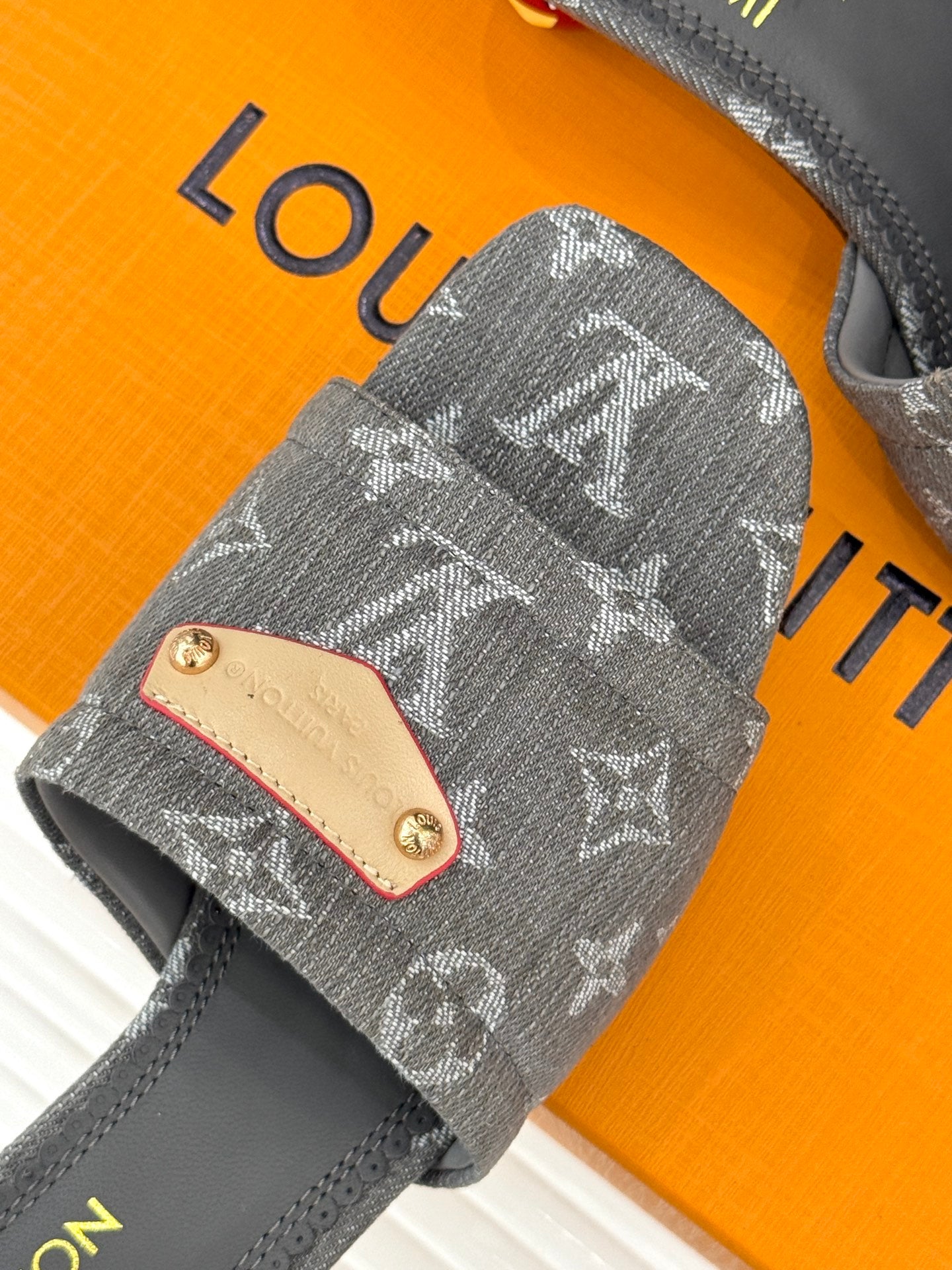 Women's gray monogram mule with close-up tan studded front plate and stitching