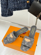 Pair of women's gray monogram slide mules with tan studded strap