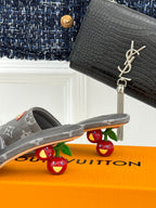 Women's gray monogram mule slide with open toe and tan buckle on front strap