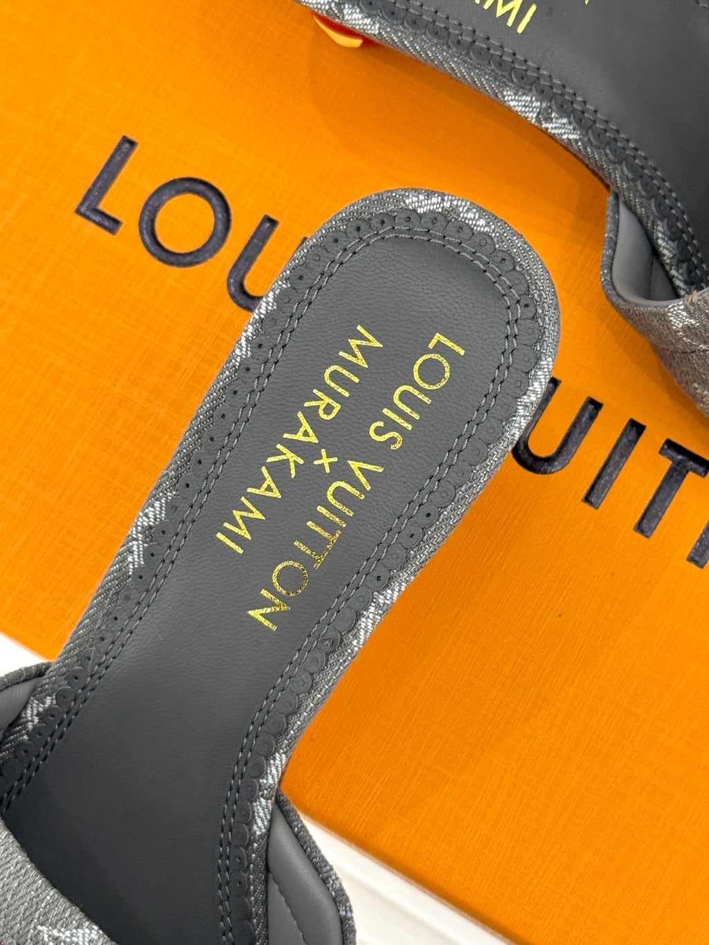 Women's gray monogram mule slide showing gray footbed text and padded lining