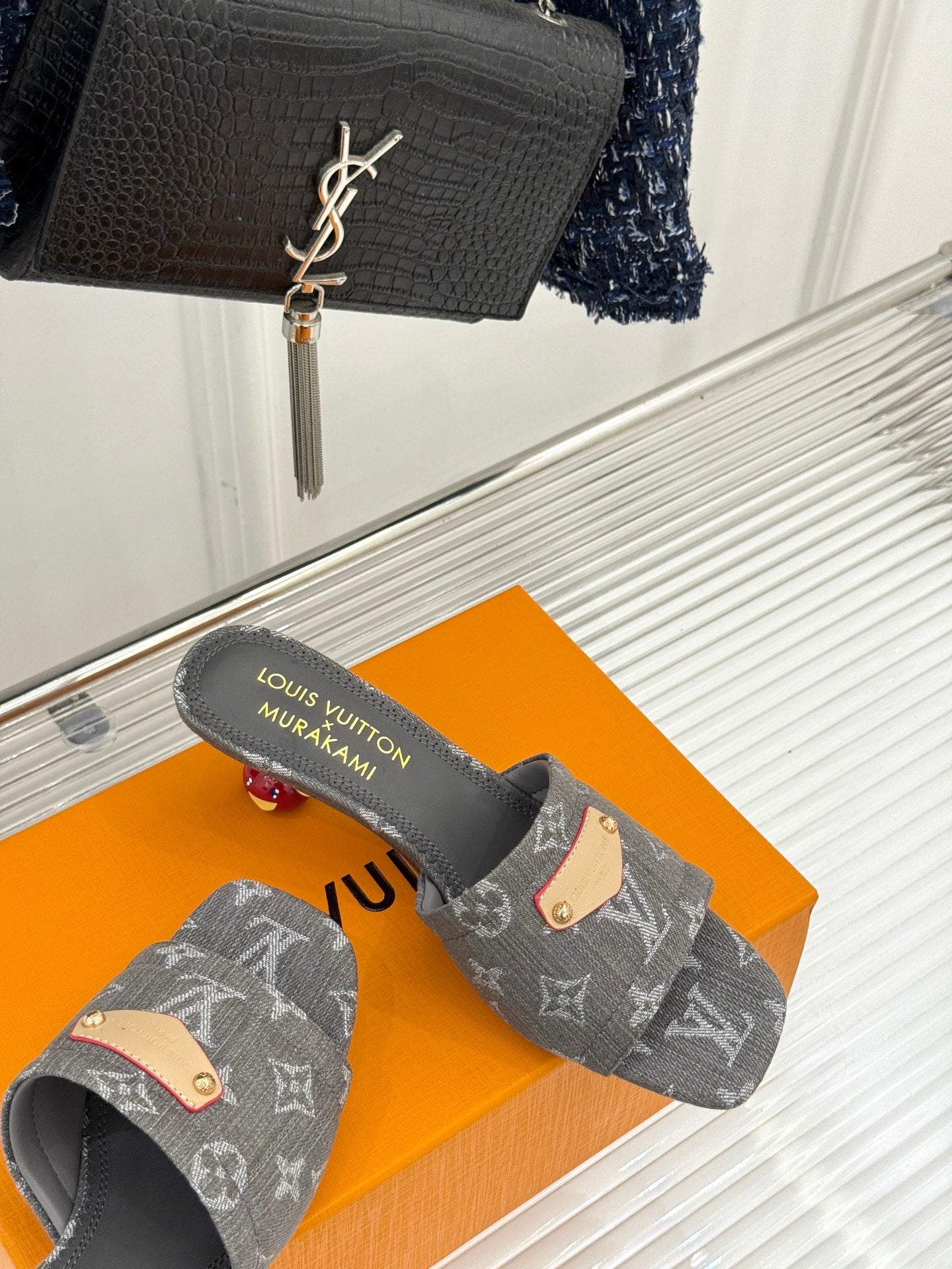 Women's gray monogram mule slides with tan buckle detail and textured gray sole