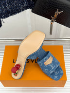 Blue Monogram slide sandals with open toe on orange box, beige sole