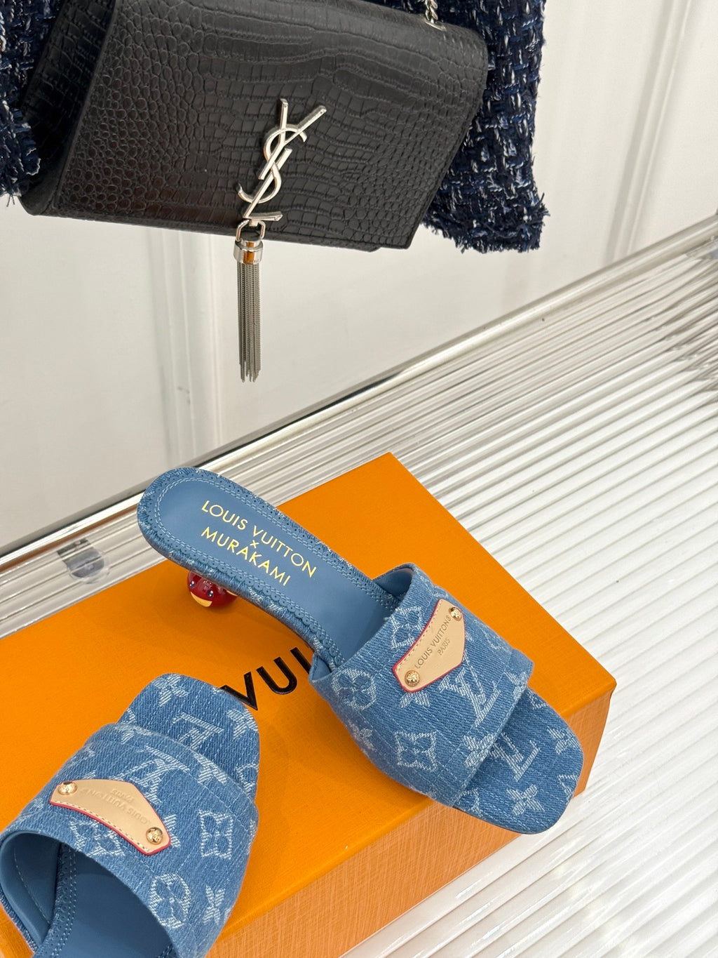 Blue Monogram slide sandals on orange box, open-toe slip-on design