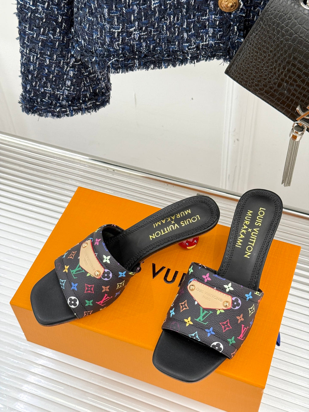 Pair of black slide sandals with multicolor monogram-pattern straps
