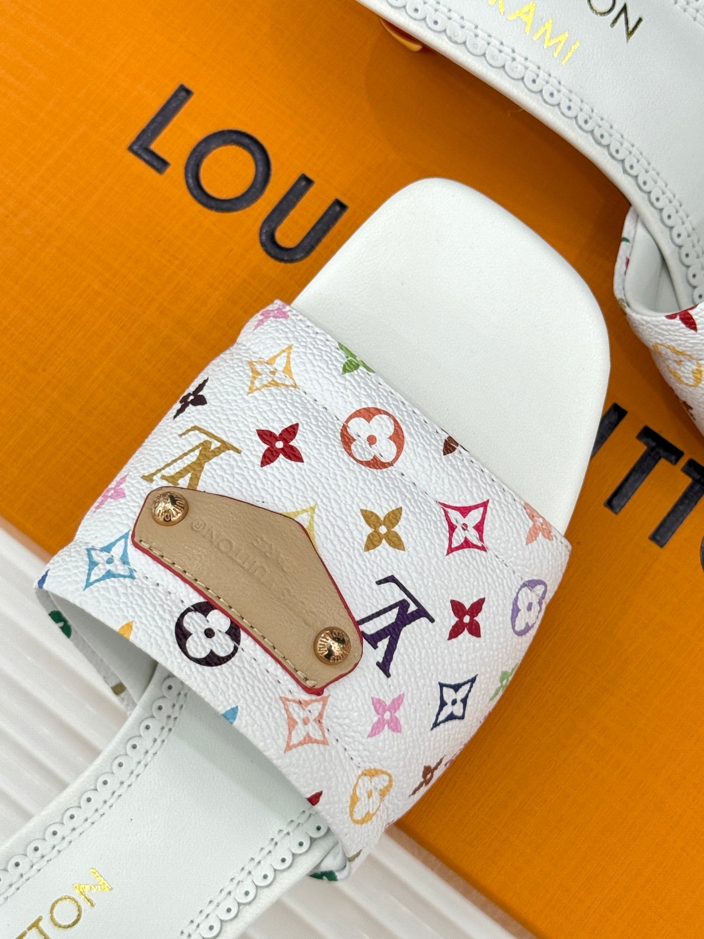 White slide sandal with multicolor monogram logo strap and gold hardware