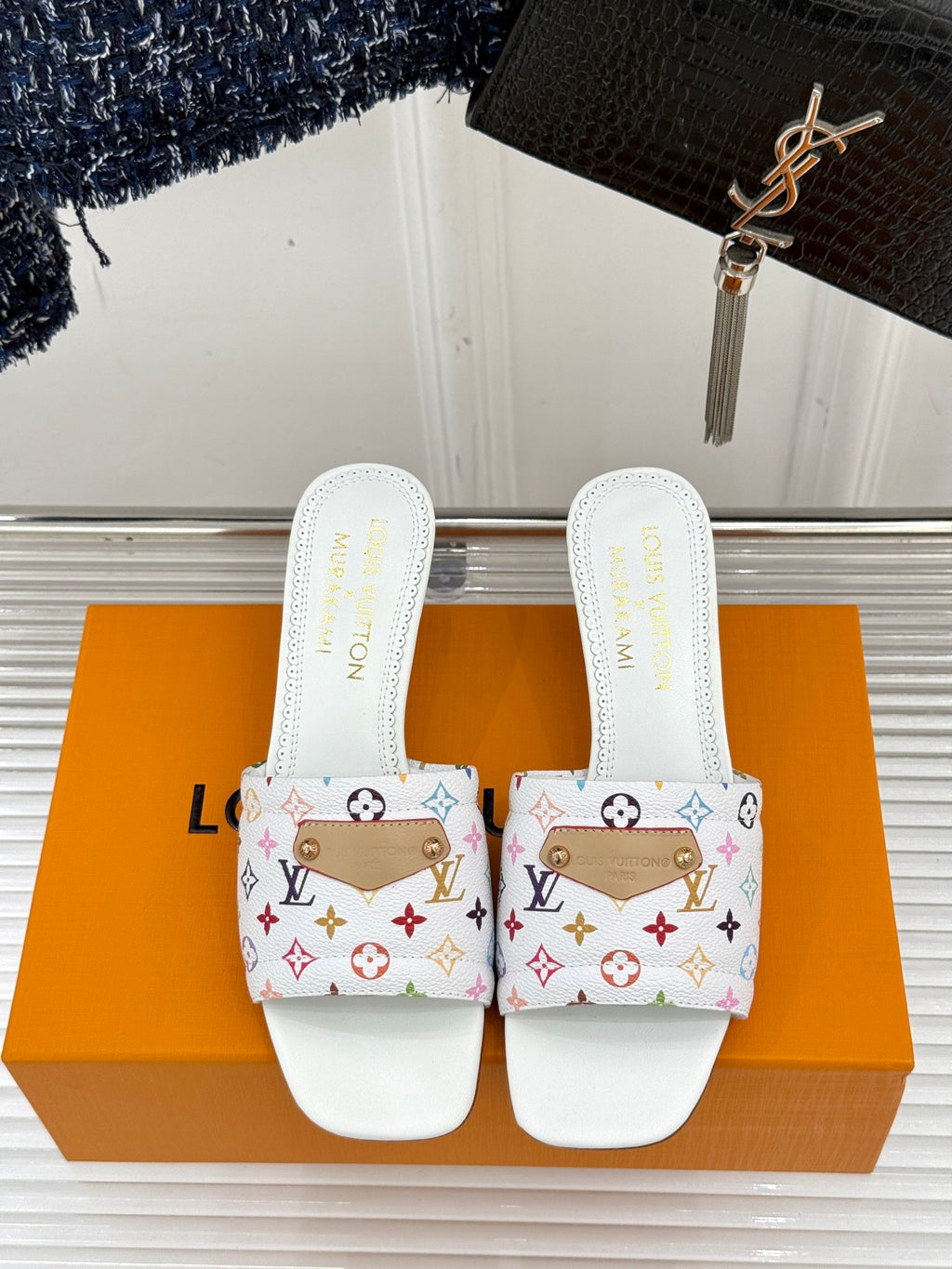 White logo slide sandals with multicolor patterned strap and flat sole