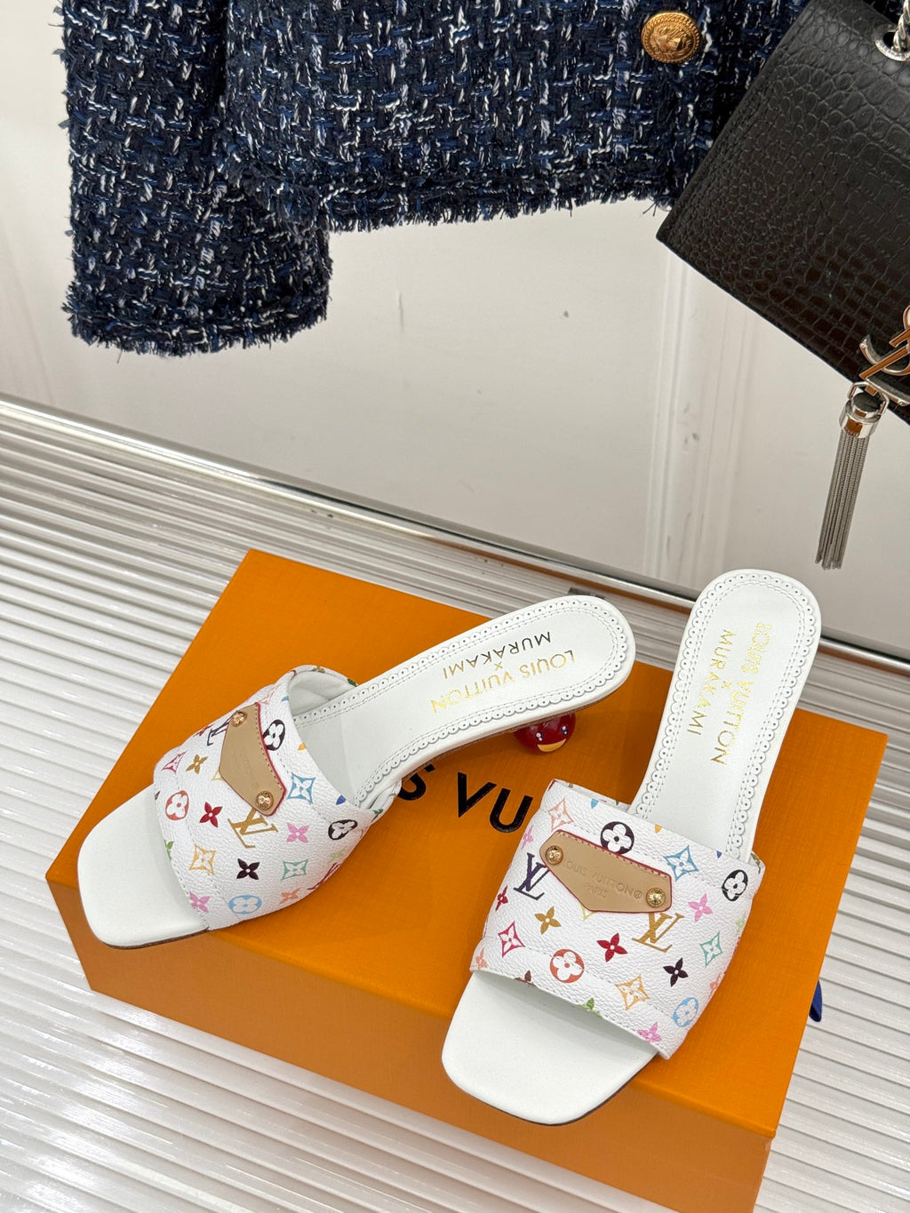 White slip-on sandals with multicolor logo strap and flat heel