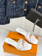 Pair of white monogram slide sandals with patterned crossover strap