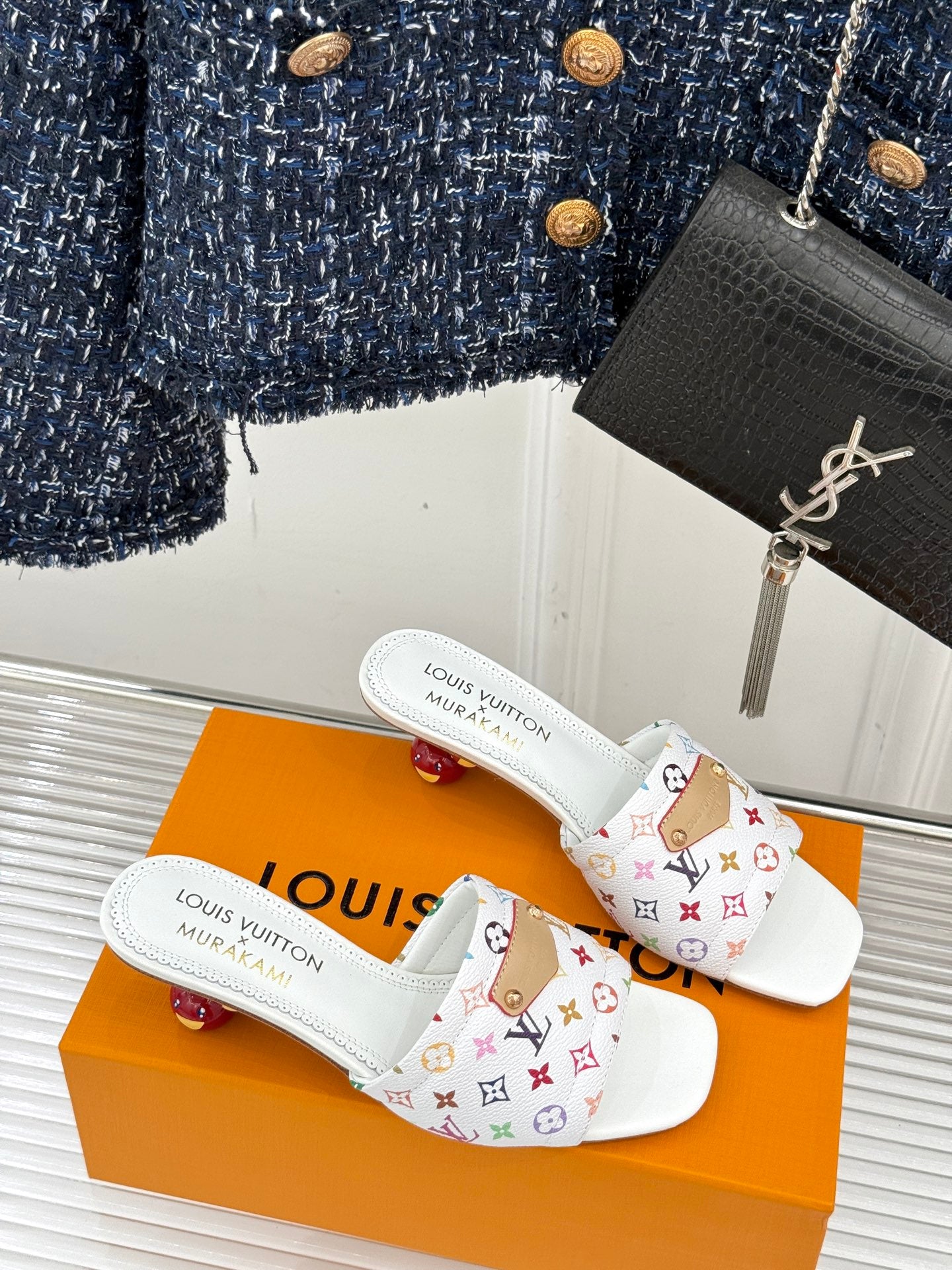 Pair of white monogram slide sandals with patterned crossover strap