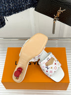 Light beige slide sandal with patterned white upper and flat sole