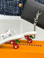White monogram slide sandals with flat sole and patterned strap detail